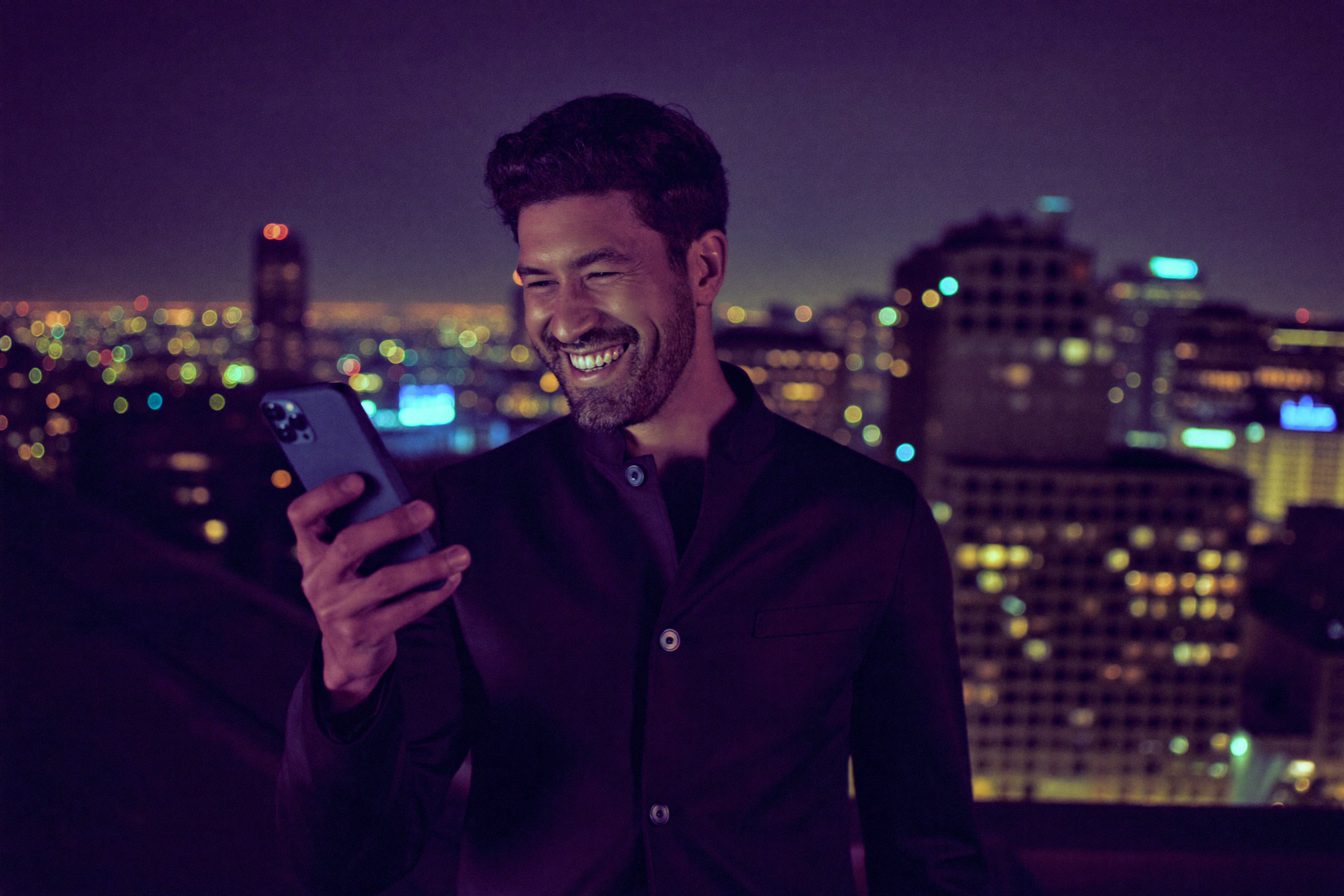 A founder relaxing on a couch, checking a Slack notification on his phone