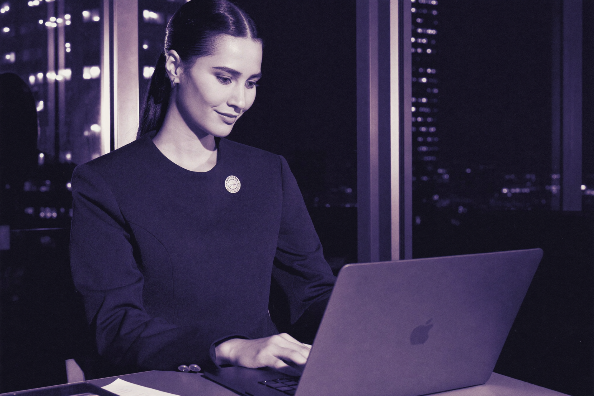 A founder leaning back from her laptop, satisfied, city lights behind her